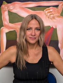 Louise Bonnet in front of her painting Red Study, 2022, oil on linen, picturing a distorted female figure in a powerful stance, feet firmly planted and moving forward. Her hand is digging into the flesh of her hip and a red conical shape streams down from between her legs.